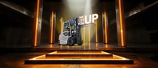 Forklift Truck lifts 3D lettering "we lift you up" on a plattform