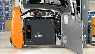 Close-up of a forklift with an open side panel, revealing a large black Li-Ion battery
