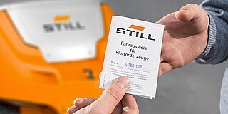 Mitarbeiter erhält Fahrausweis für Flurförderzeuge von STILL – Staplerschein Übergabe für sicheres Fahren mit Gabelstaplern und Lagertechnikfahrzeugen