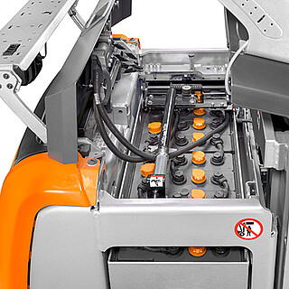 Nahaufnahme eines geöffneten Batteriefachs an einem STILL Gabelstapler, das den Blick auf eine große Blei-Säure-Batterie mit vielen gelben Zellenverschlüssen freigibt.